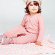 Load image into Gallery viewer, Baby girl wearing a pink long sleeve romper and sitting on a pink baby blanket