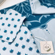 Load image into Gallery viewer, Close-up of Akaash set with bib, burp cloth, short sleeve onesie and blanket