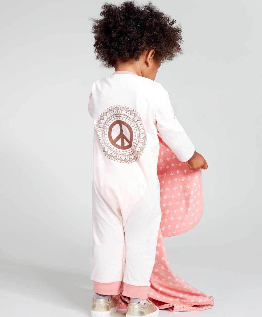 Baby wearing a pink long sleeve one piece with peace sign print on the back