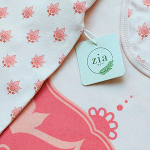 Close-up of Zia NYC tag on baby blanket with lotus flower print