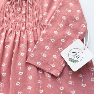 Close up of sleeve of pink one piece baby romper with small heart print